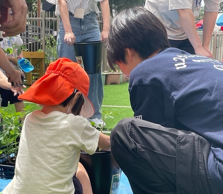 ミニトマトの苗を植えている子どもたち