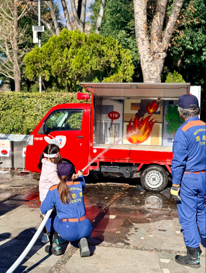 子どもが消防車に放水している様子
