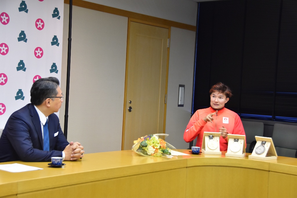 メダルを前に談笑する様子