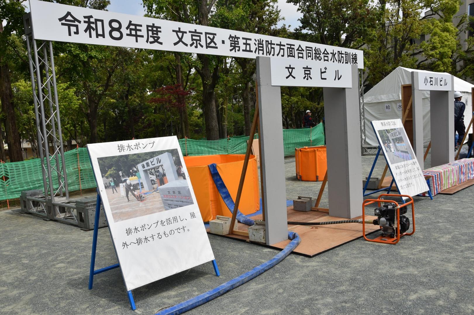排水ポンプと令和8年度文京区第五消防法面合同総合水防訓練の看板の写真