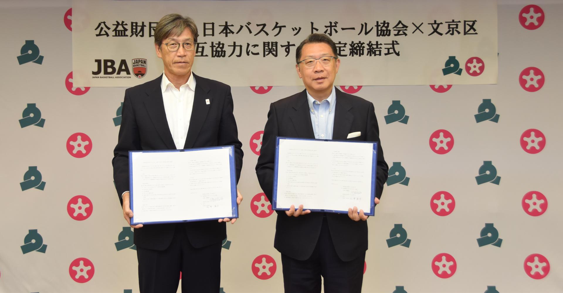 成澤区長と渡邊事務総長が協定書を持っている様子